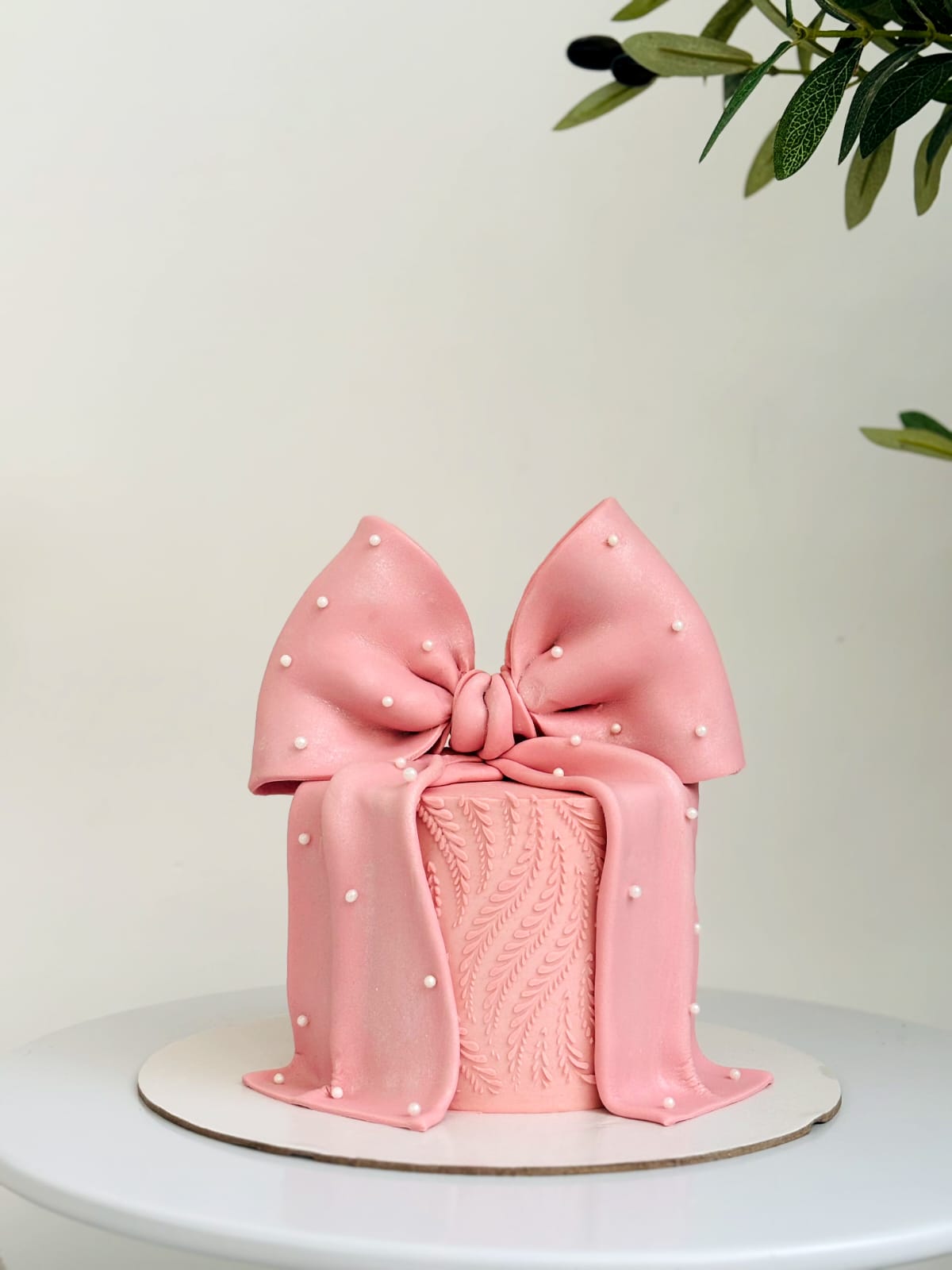 Blush pink bow cake with pearl accents
