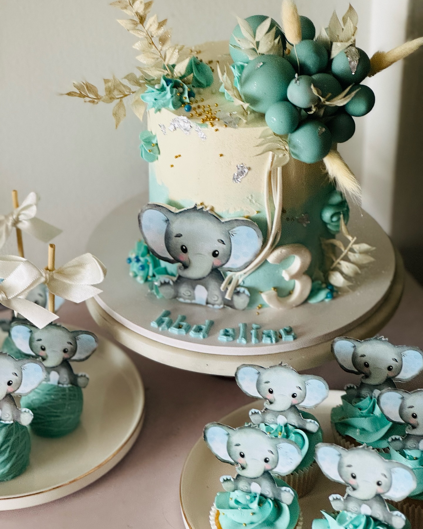 Soft blue elephant themed cake with matching cupcakes
